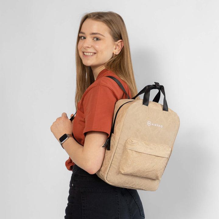 Rucksack Qube Sand von Airpaq getragen von Model Frau