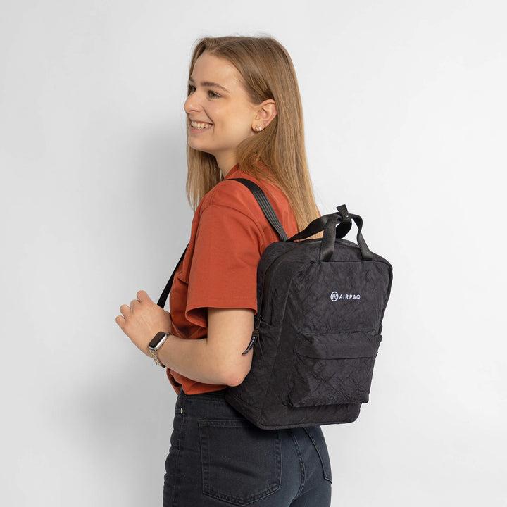 Rucksack Qube schwarz von Airpaq getragen an Model