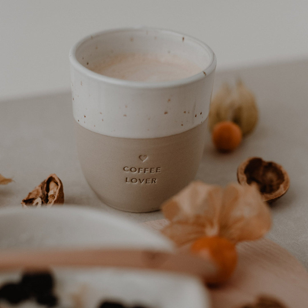 Becher Coffee lover mit Kaffee auf dem Frühstückstisch