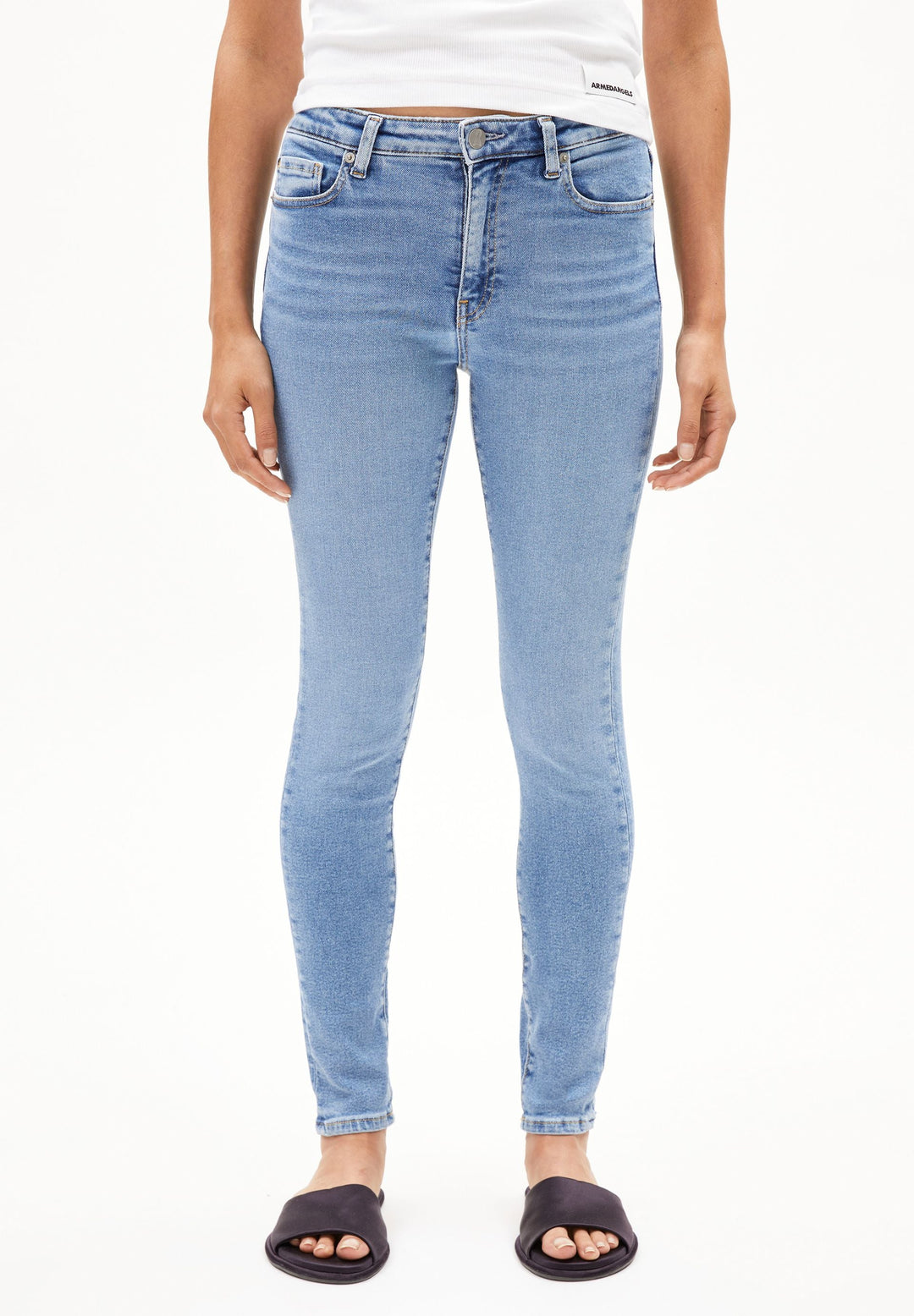 Model trägt Jeans TILLAA Skinny Mid Waist in Dove von ARMEDANGELS