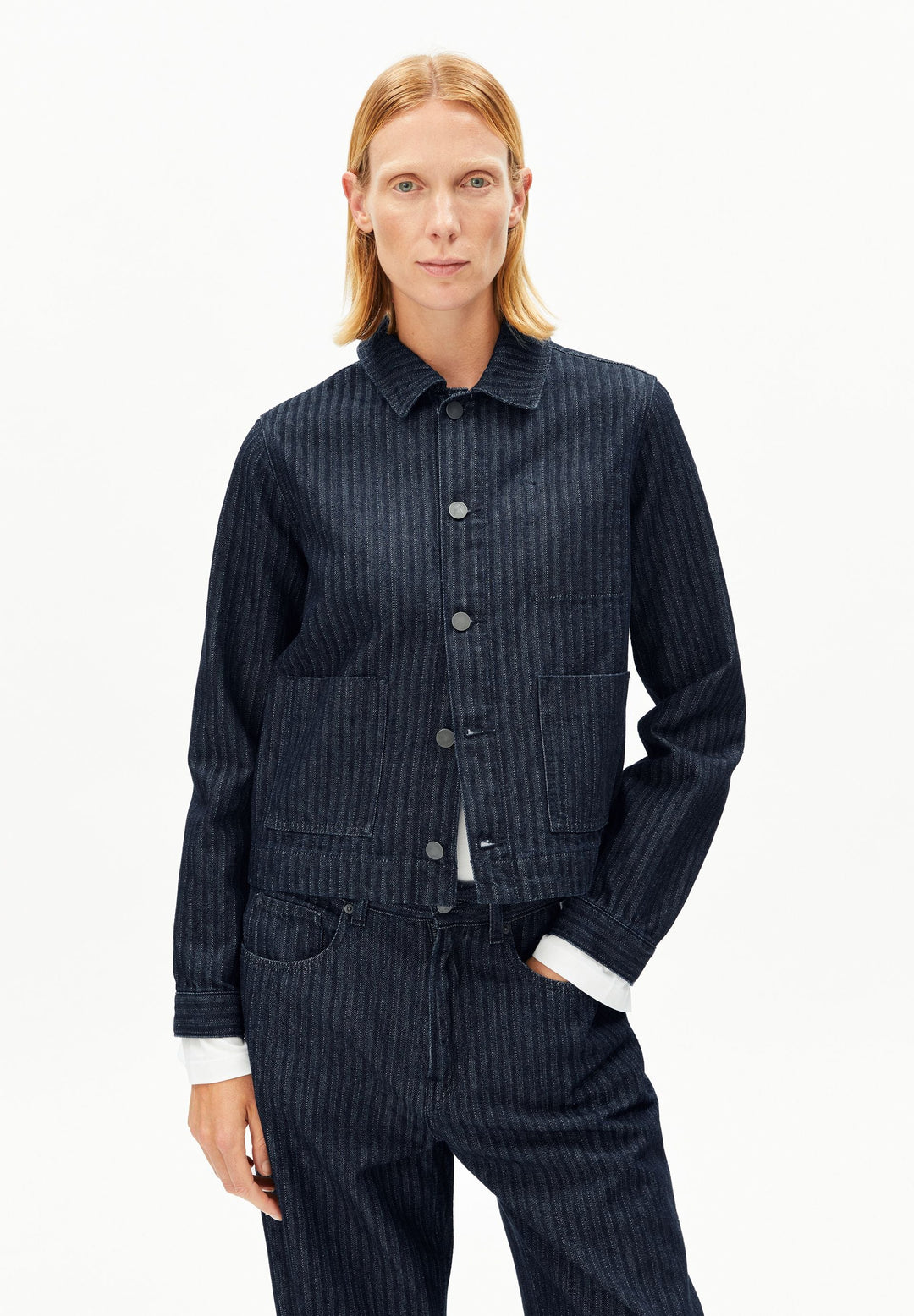Model trägt Jeansjacke Herringbone Denim Chore in Rinse von ARMEDANGELS