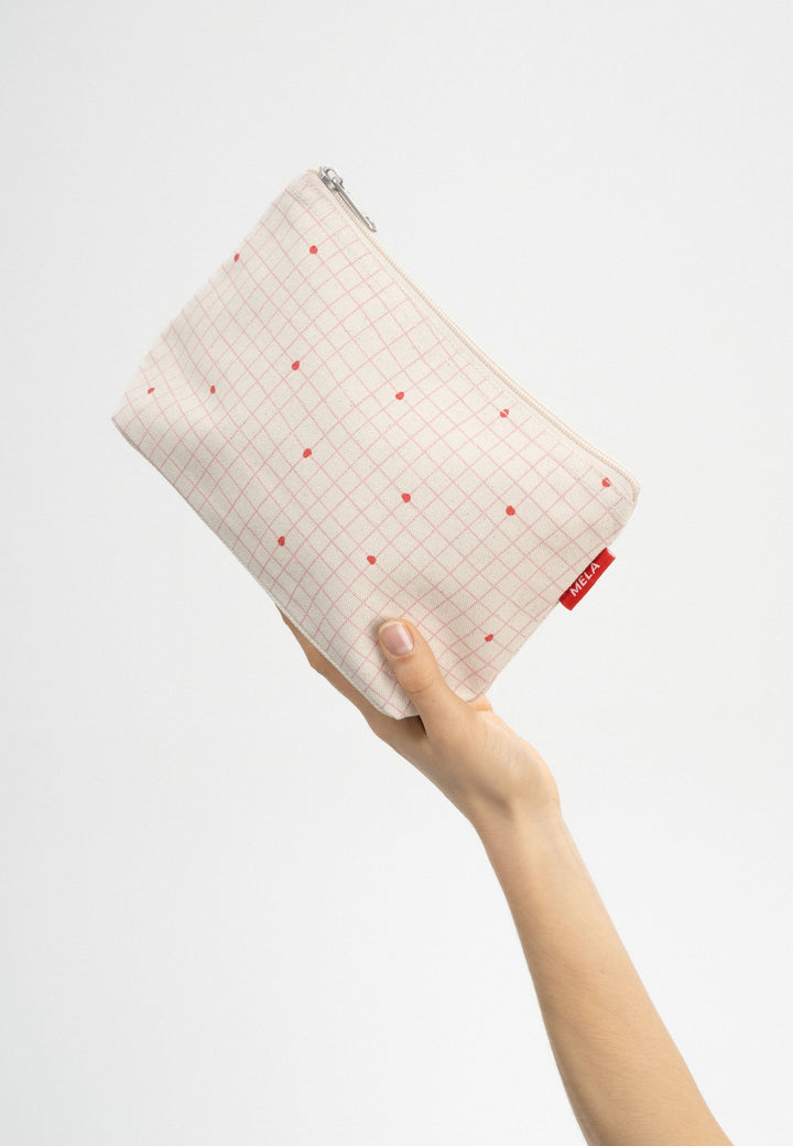 Grosse Kosmetiktasche Greige Candy Grid Print von Mela in der Hand gehalten