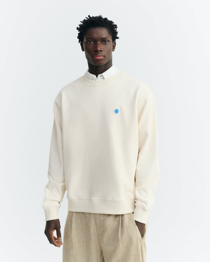 Sweatshirt Leon Ecru mit blauer Sonne von Thinking MU, Vorderansicht am Model