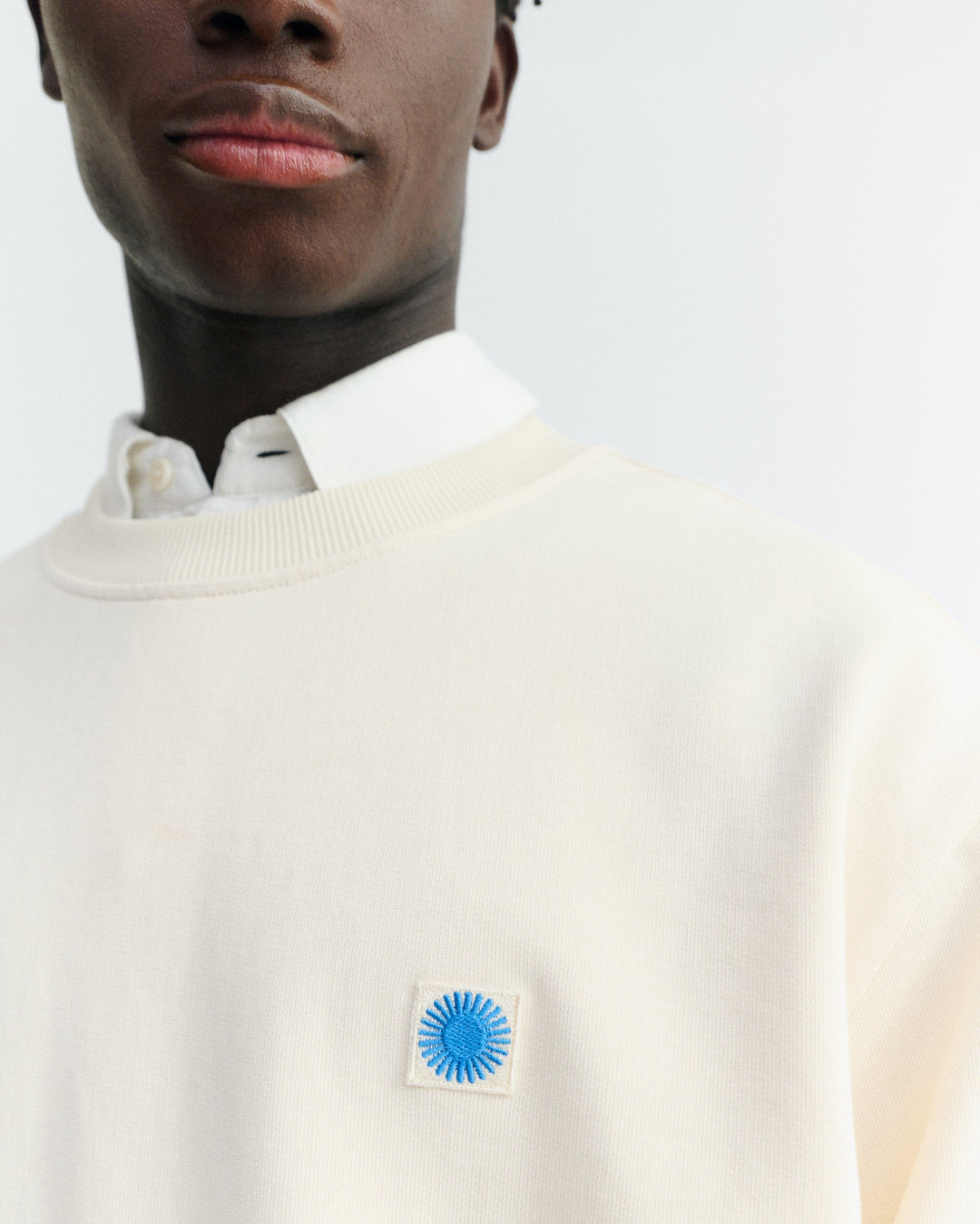 Sweatshirt Leon Ecru von Thinking MU, Nahaufnahme gesticktes Logo-Patch auf der Brust