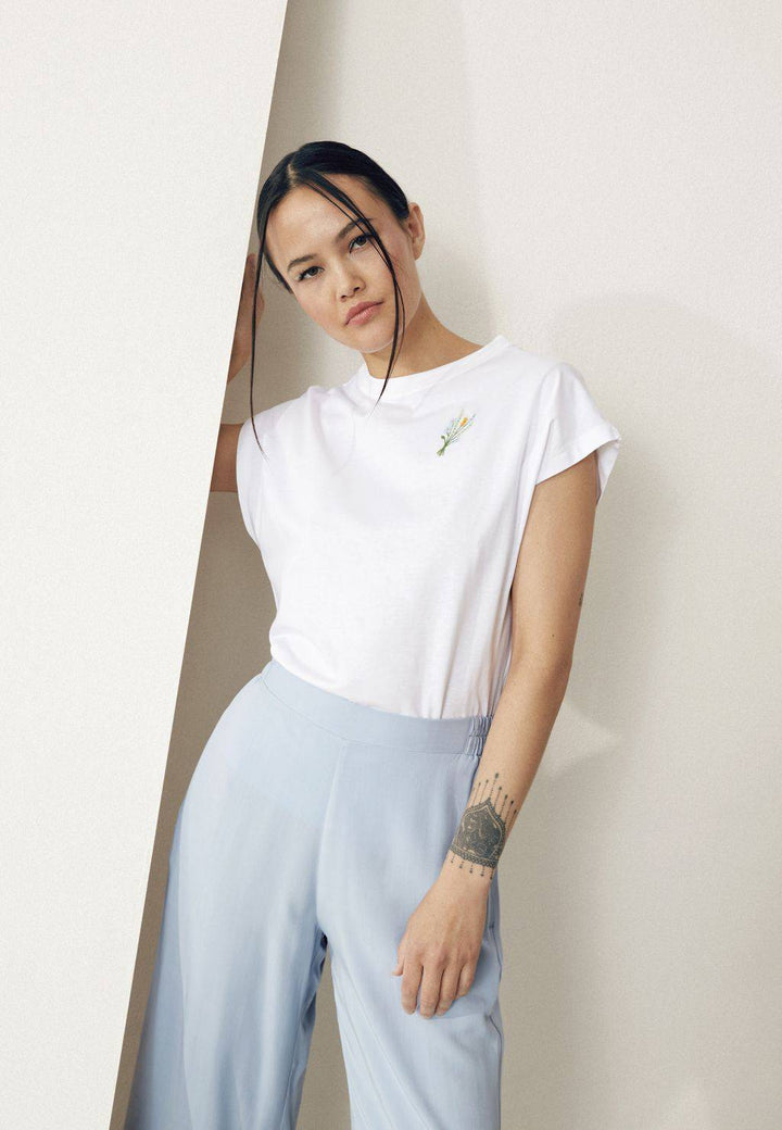 T-Shirt GBLaila White von Givn Berlin – Model angelehnt an Wand